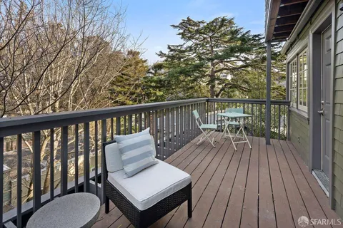 a view of a balcony with two chairs and wooden floor