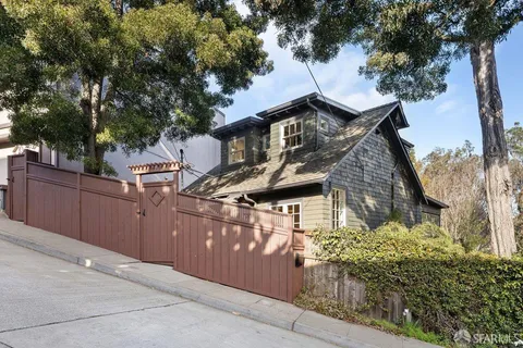 a front view of a house with a tree