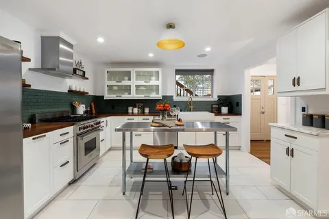 a kitchen with a sink a counter top space stainless steel appliances cabinets and a counter top space