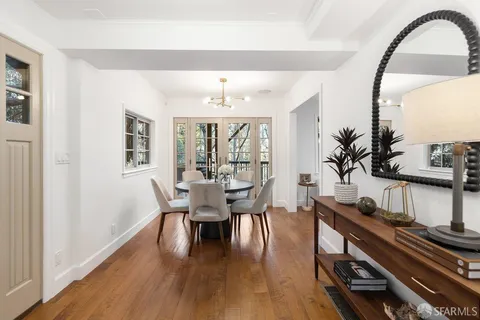 a dining room with furniture a chandelier and wooden floor