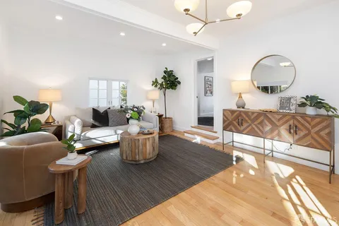 a living room with furniture a window and wooden floor