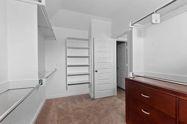 a view of walk in closet with empty racks