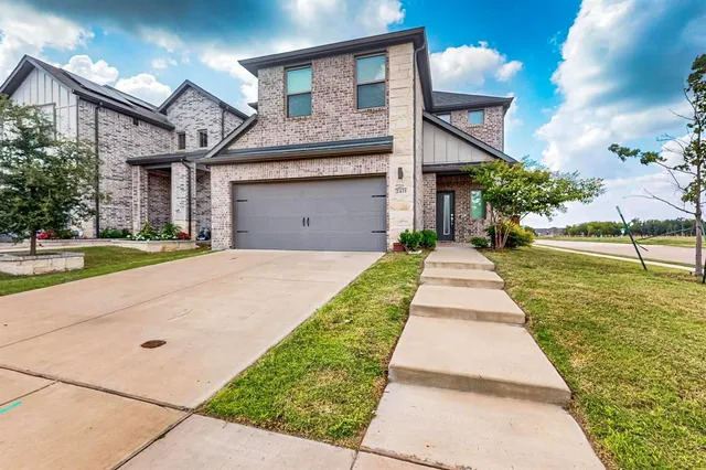 a front view of a house with a yard and potted plants