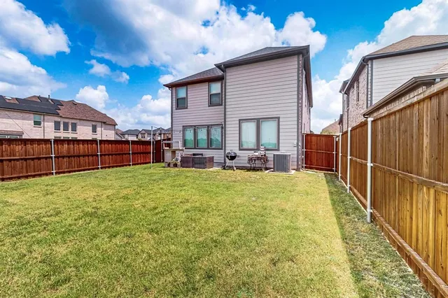 a view of a backyard with couches plants and wooden fence