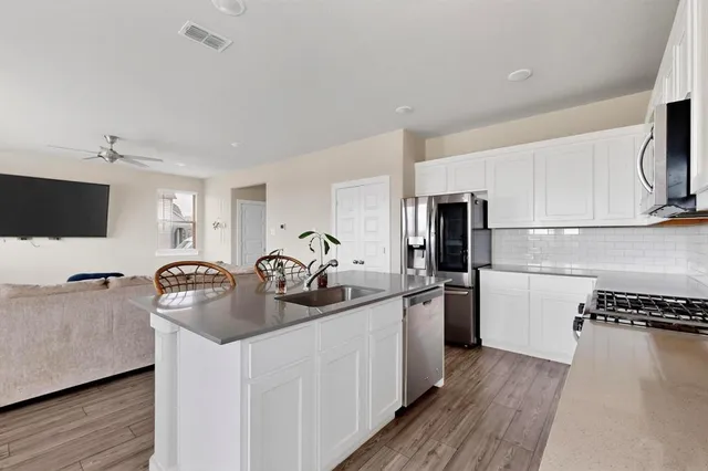 a kitchen with stainless steel appliances granite countertop a sink stove and refrigerator