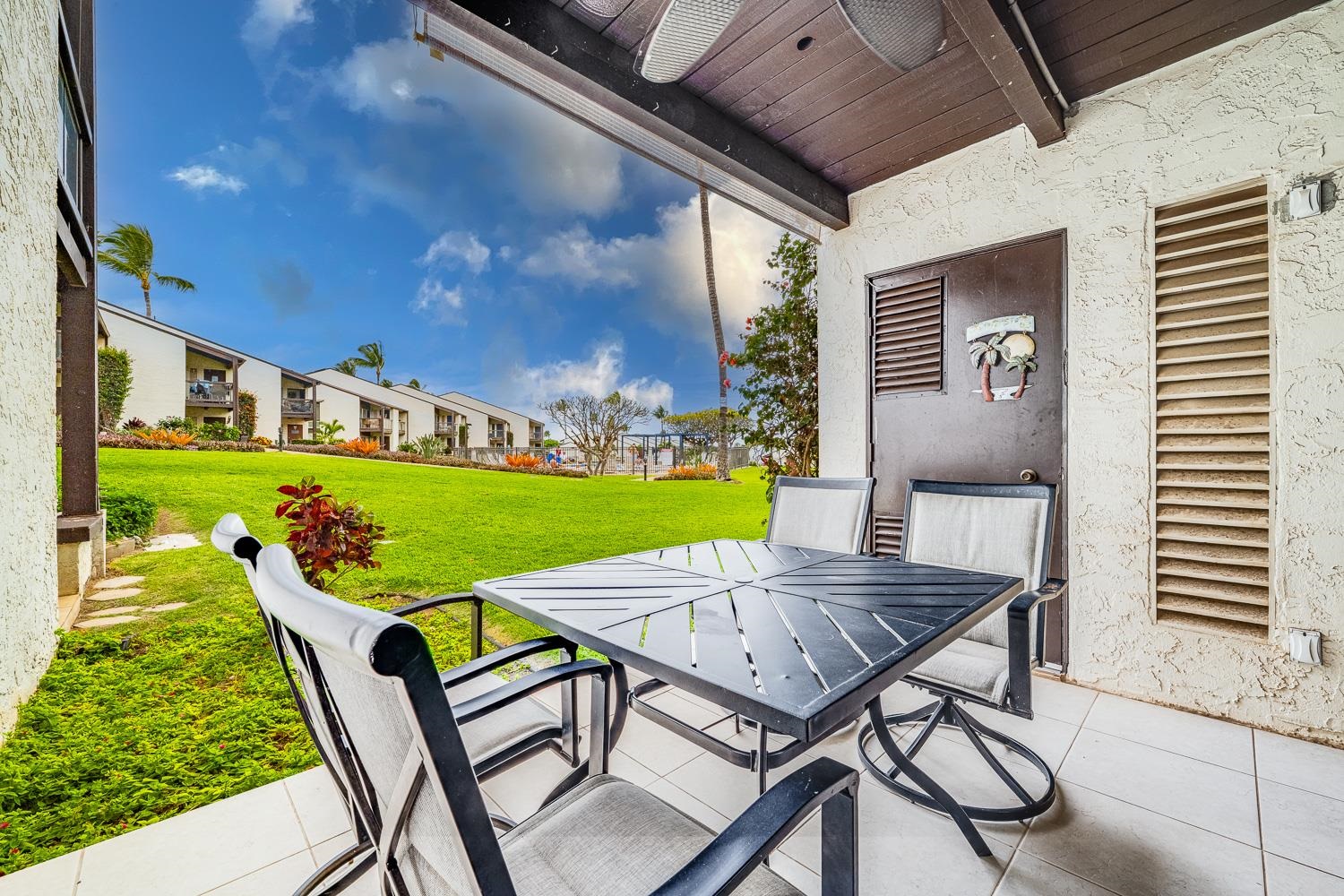 2737 South Kihei Road, Unit 142 Kihei, HI 96753 - Photo 4 of 43 a view of a chairs and table in patio with a yard