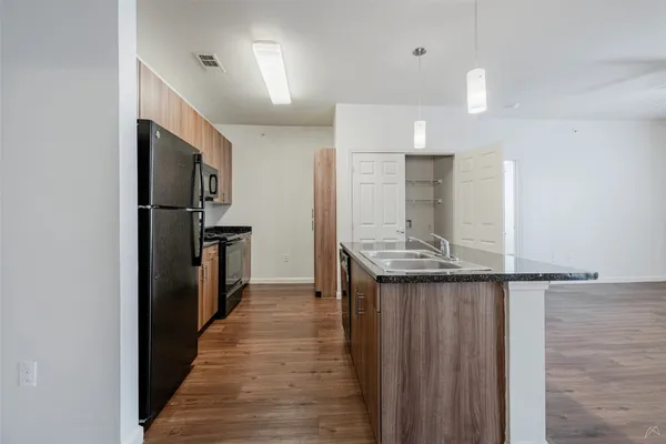 a kitchen with stainless steel appliances granite countertop a refrigerator and a sink