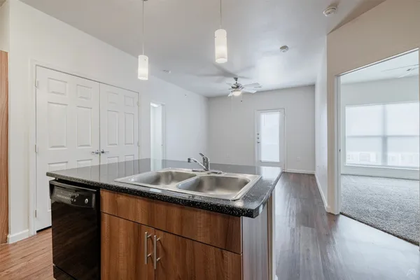 a kitchen with stainless steel appliances granite countertop a sink and dishwasher with wooden floor