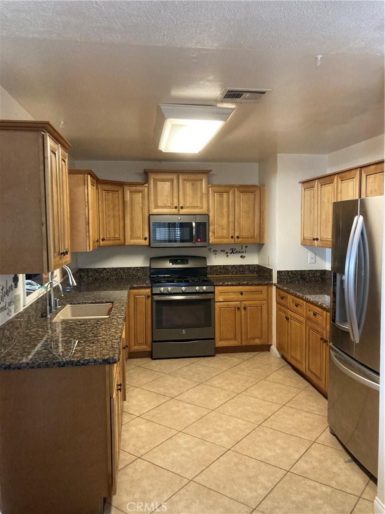 1201 Elizabeth Street Barstow, CA 92311 - Photo 8 of 19 a kitchen with a stove a sink and a refrigerator