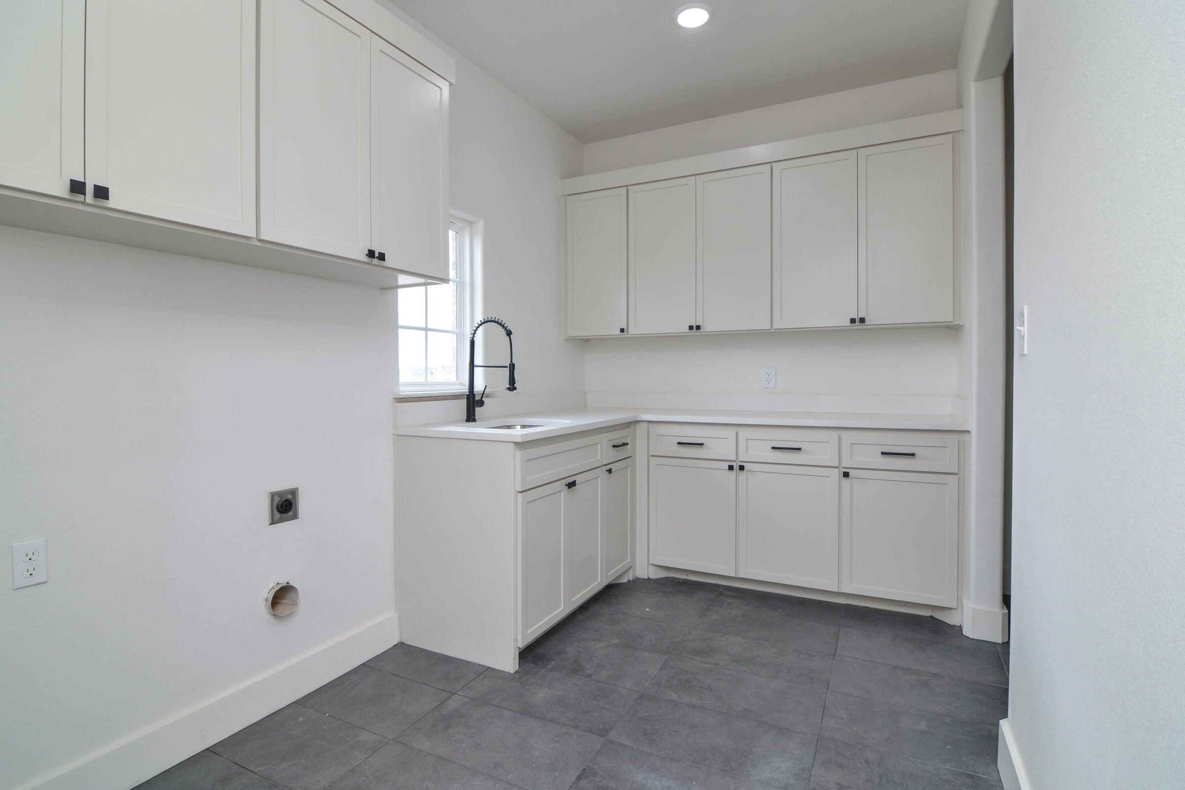 7801 56th Street Lubbock, TX 79407 - Photo 29 of 29 a kitchen with white cabinets and white appliances
