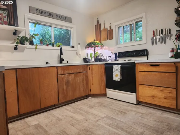 a kitchen with stainless steel appliances a sink and a large window