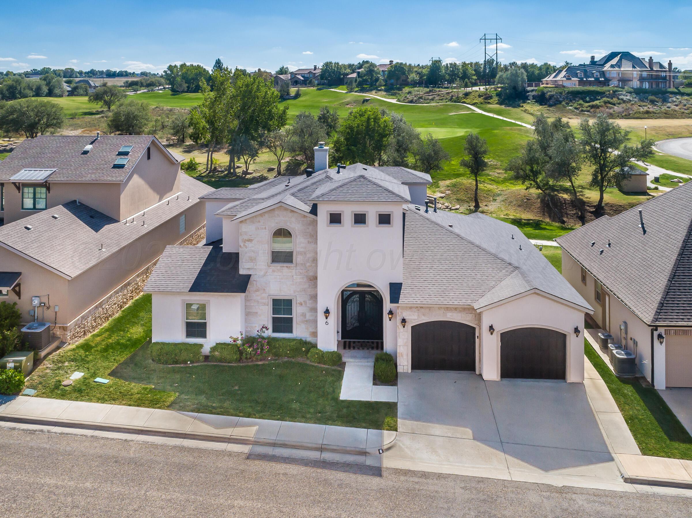 an aerial view of a house with a garden and lake view