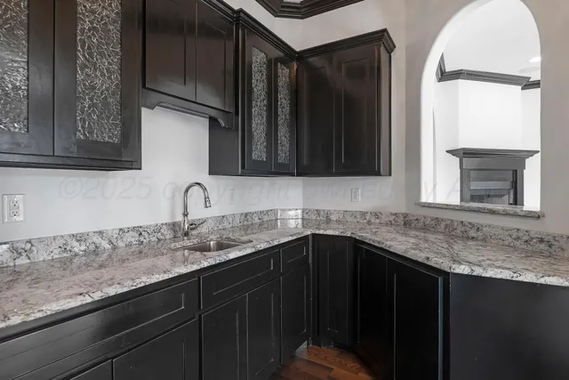 a kitchen with granite countertop a sink stove and cabinets