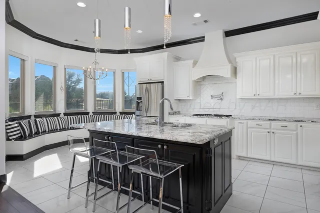 a kitchen with stainless steel appliances granite countertop a stove a sink dishwasher and a refrigerator with wooden floor