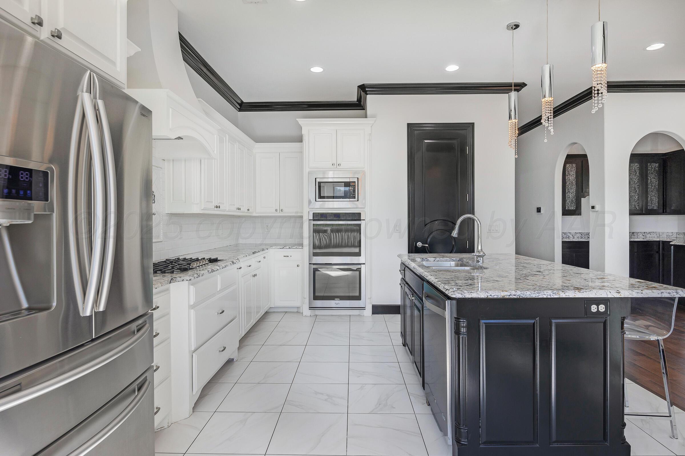 6 Merion Place Amarillo, TX 79124 - Photo 16 of 46 a kitchen with stainless steel appliances granite countertop a kitchen island a stove a sink and a refrigerator