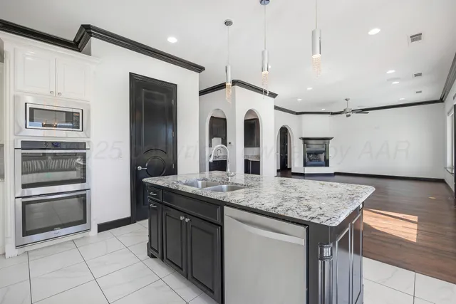 a kitchen with stainless steel appliances granite countertop a sink and a refrigerator