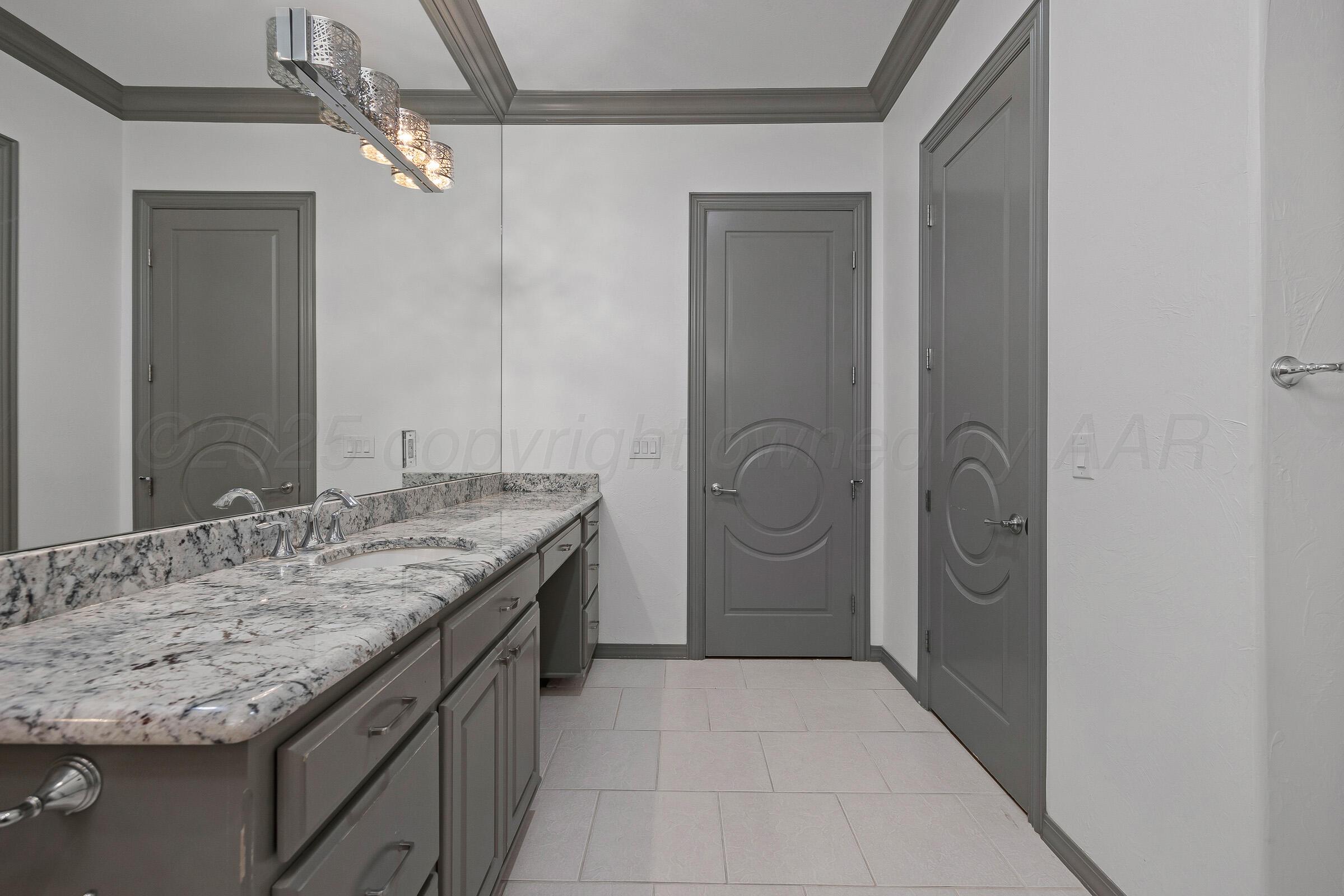 6 Merion Place Amarillo, TX 79124 - Photo 22 of 46 a bathroom with a granite countertop sink a mirror and a shower