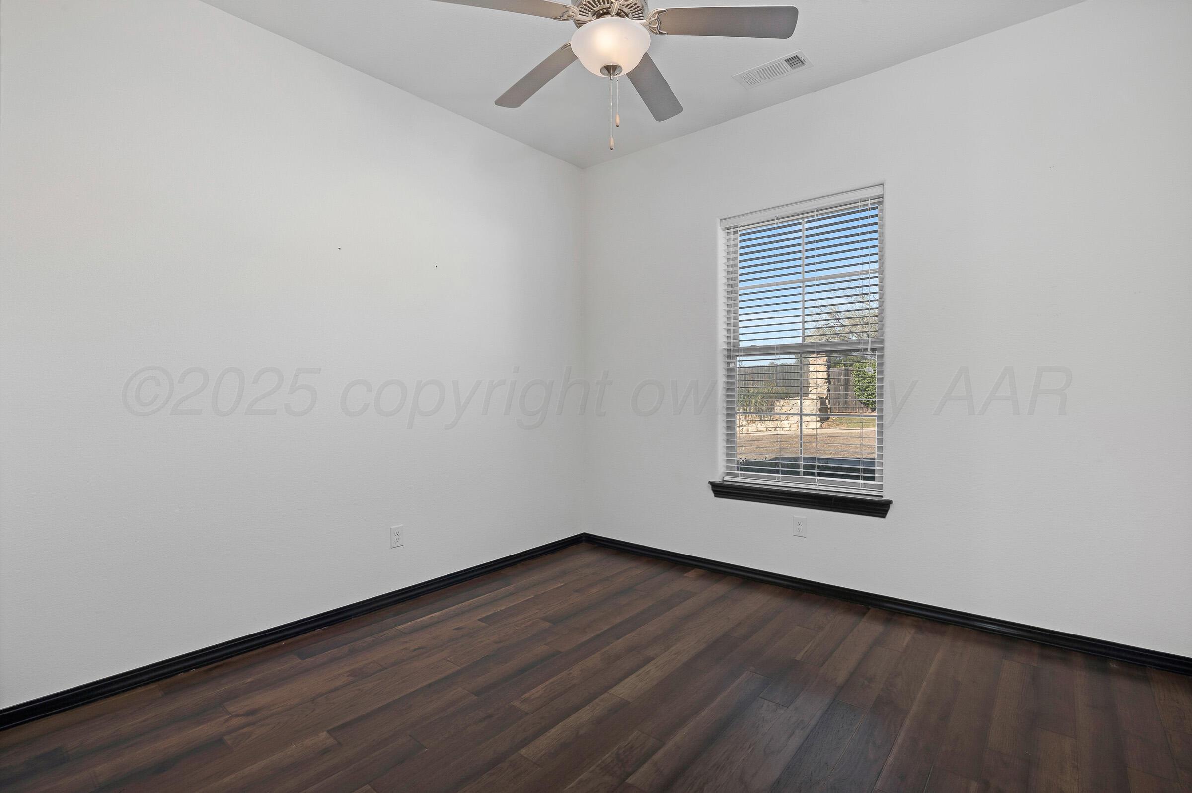 6 Merion Place Amarillo, TX 79124 - Photo 25 of 46 an empty room with wooden floor chandelier fan and windows