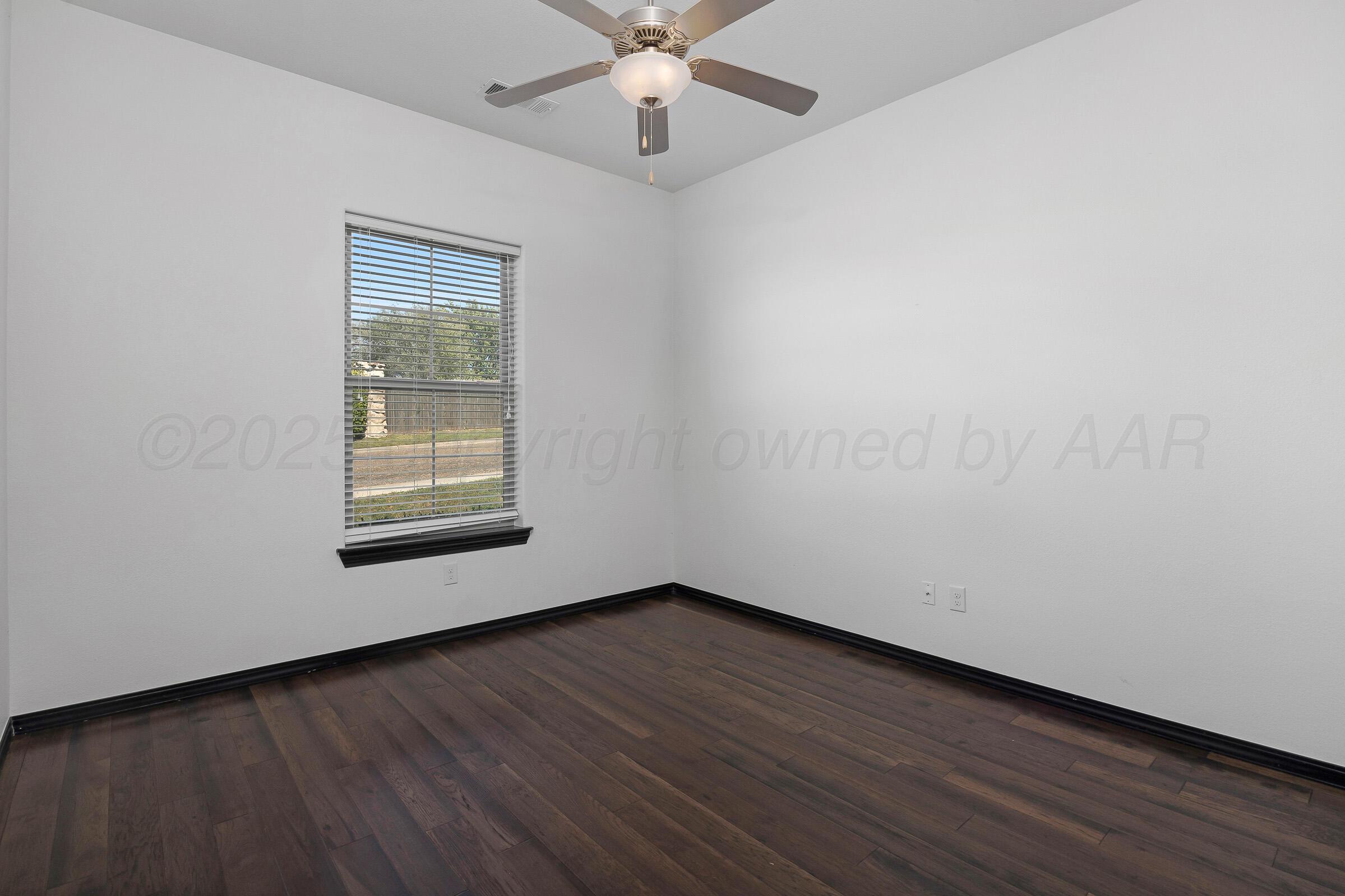 6 Merion Place Amarillo, TX 79124 - Photo 26 of 46 an empty room with wooden floor chandelier fan and windows