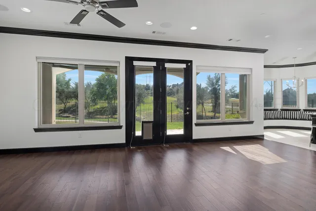 a view of a livingroom with wooden floor and a ceiling fan