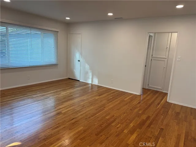 a view of a kitchen with wooden floor and a window