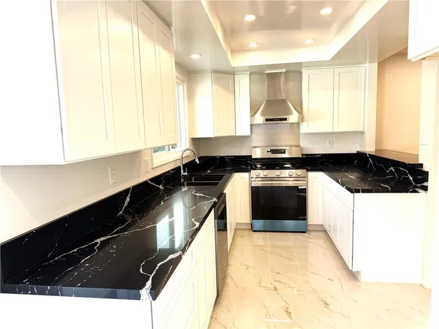 a kitchen with a stove a sink and a window