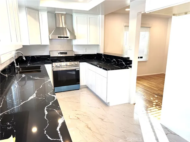 a kitchen with granite countertop a stove and a sink