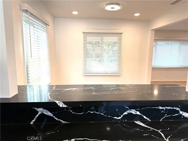 a view of a room with kitchen island granite countertop wooden floor and a window
