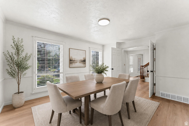 8441 Rua Branco Drive Sandy, UT 84093 - Photo 18 of 47 Dining area featuring wood-finish flooring, white walls with wainscoting, and crown molding