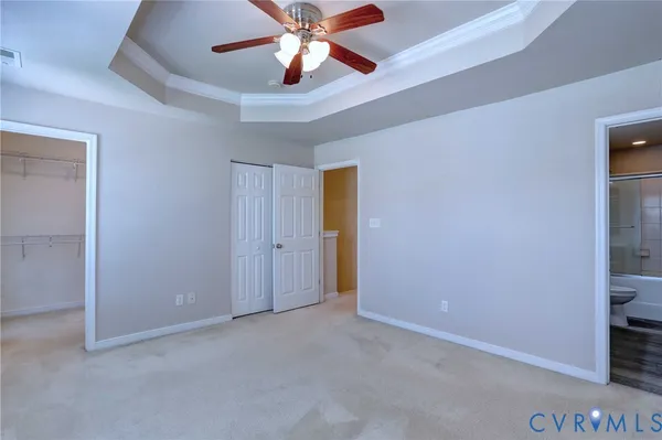 an empty room with closet and a chandelier fan