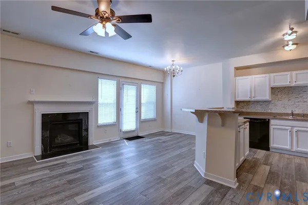 a open kitchen with a fireplace and wooden floor