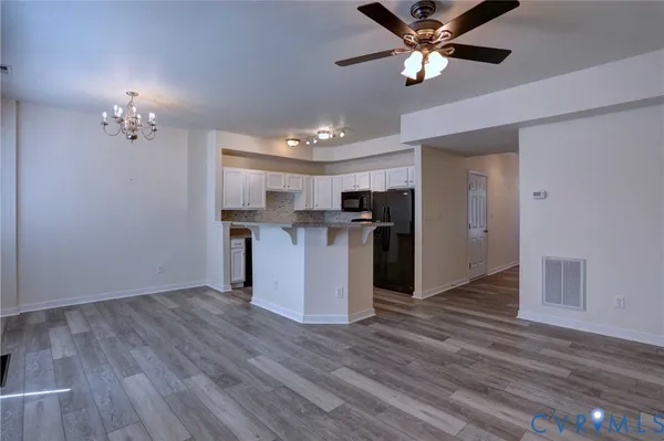 a view of a kitchen with a sink wooden floor and a ceiling fan