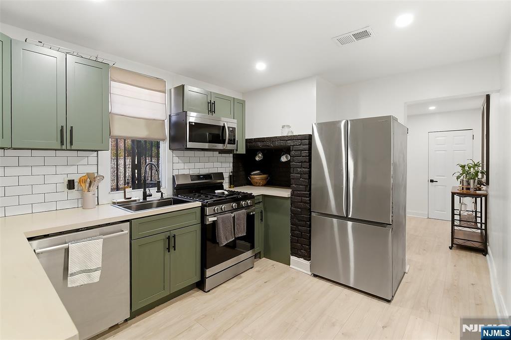 22 8th Avenue Newark, NJ 07104 - Photo 9 of 26 a kitchen with stainless steel appliances a refrigerator sink and microwave