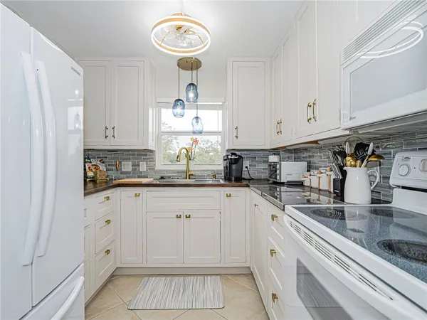 a kitchen with granite countertop a refrigerator and a sink