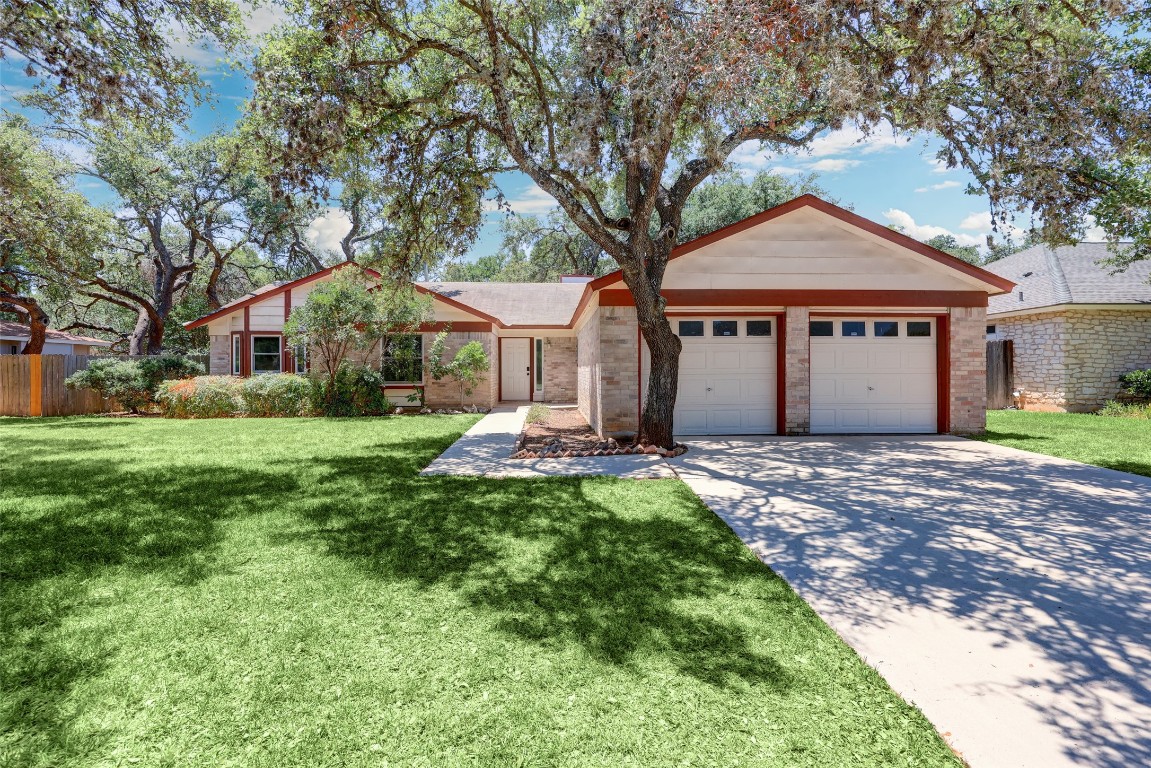 a front view of a house with a yard and trees