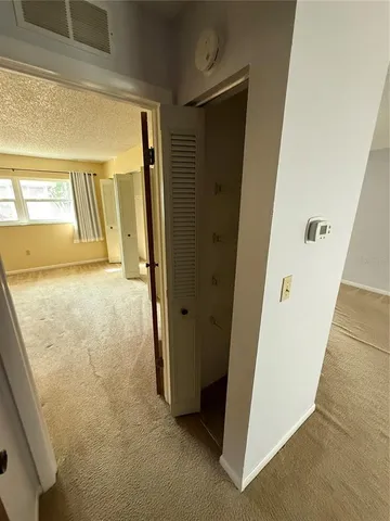 a view of a hallway with wooden floor and entryway