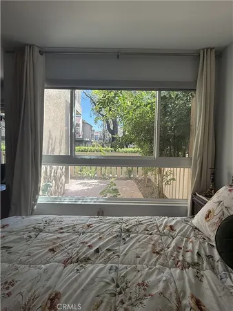 a view of a bedroom with a bed and wooden floor