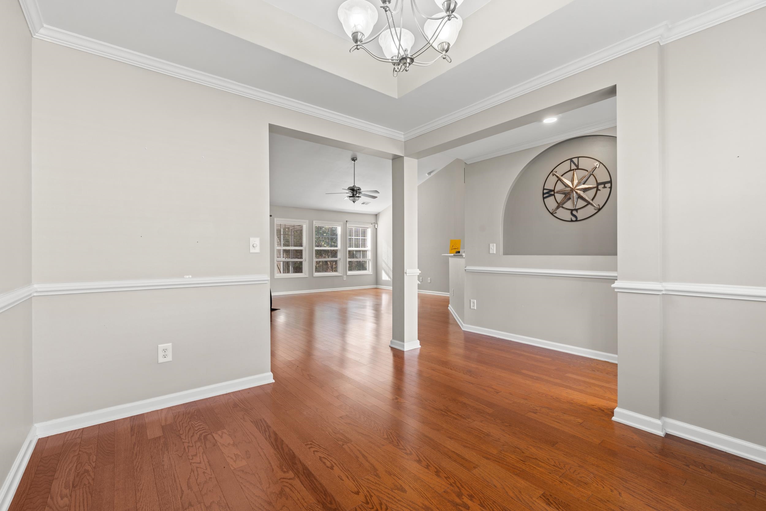 2487 Windmill Way Myrtle Beach, SC 29579 - Photo 14 of 40 Unfurnished dining area featuring dark wood finished floors, ceiling fan, crown molding, a chandelier, and a tray ceiling