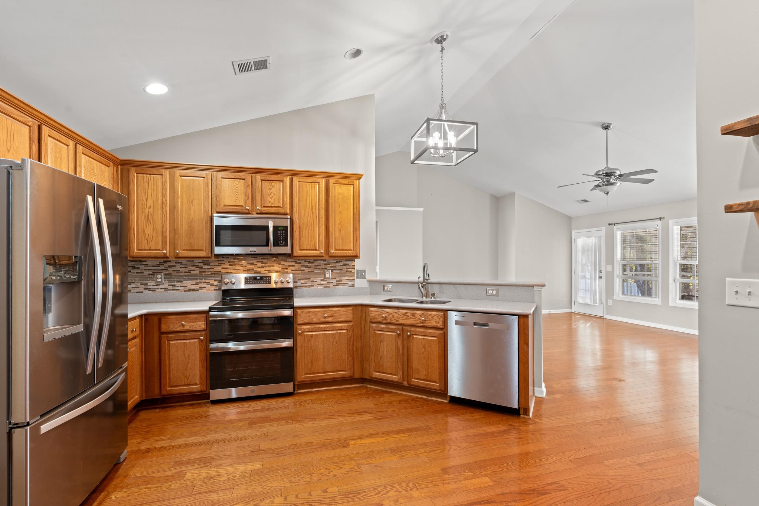 2487 Windmill Way Myrtle Beach, SC 29579 - Photo 16 of 40 Kitchen featuring appliances with stainless steel finishes, hanging light fixtures, light countertops, a chandelier, and high vaulted ceiling