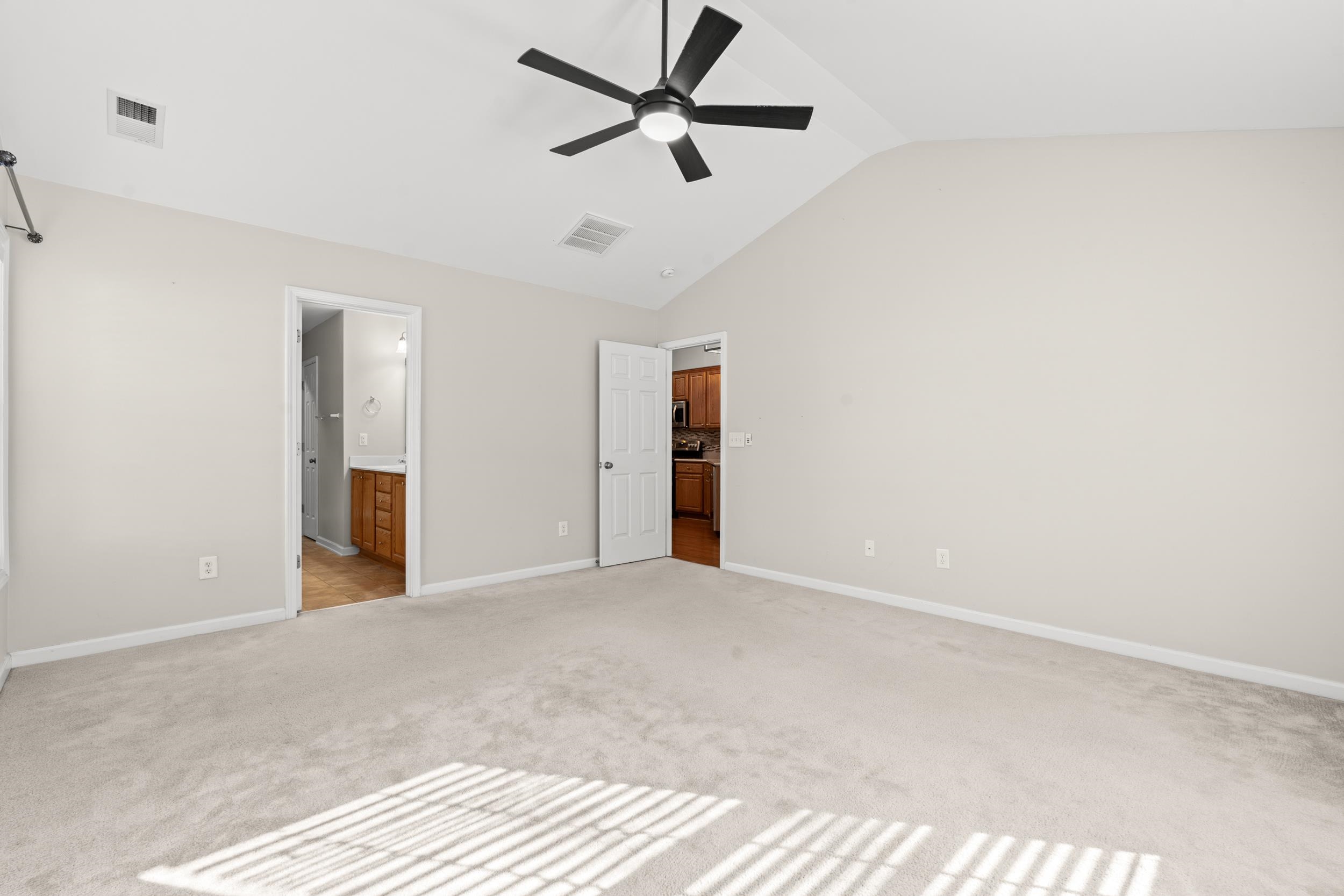 2487 Windmill Way Myrtle Beach, SC 29579 - Photo 20 of 40 Unfurnished bedroom featuring lofted ceiling, light colored carpet, a ceiling fan, and ensuite bath