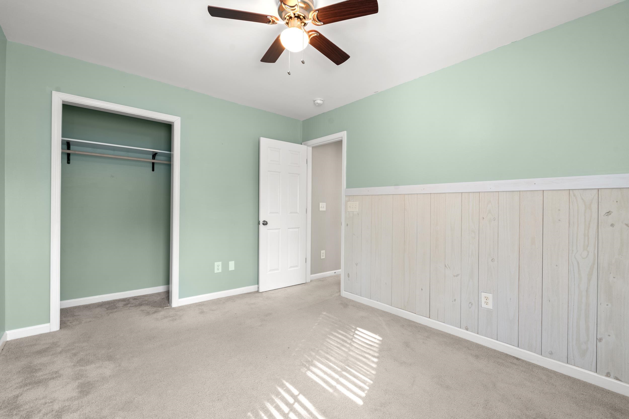 2487 Windmill Way Myrtle Beach, SC 29579 - Photo 25 of 40 Unfurnished bedroom featuring a ceiling fan, wainscoting, carpet floors, wooden walls, and a closet