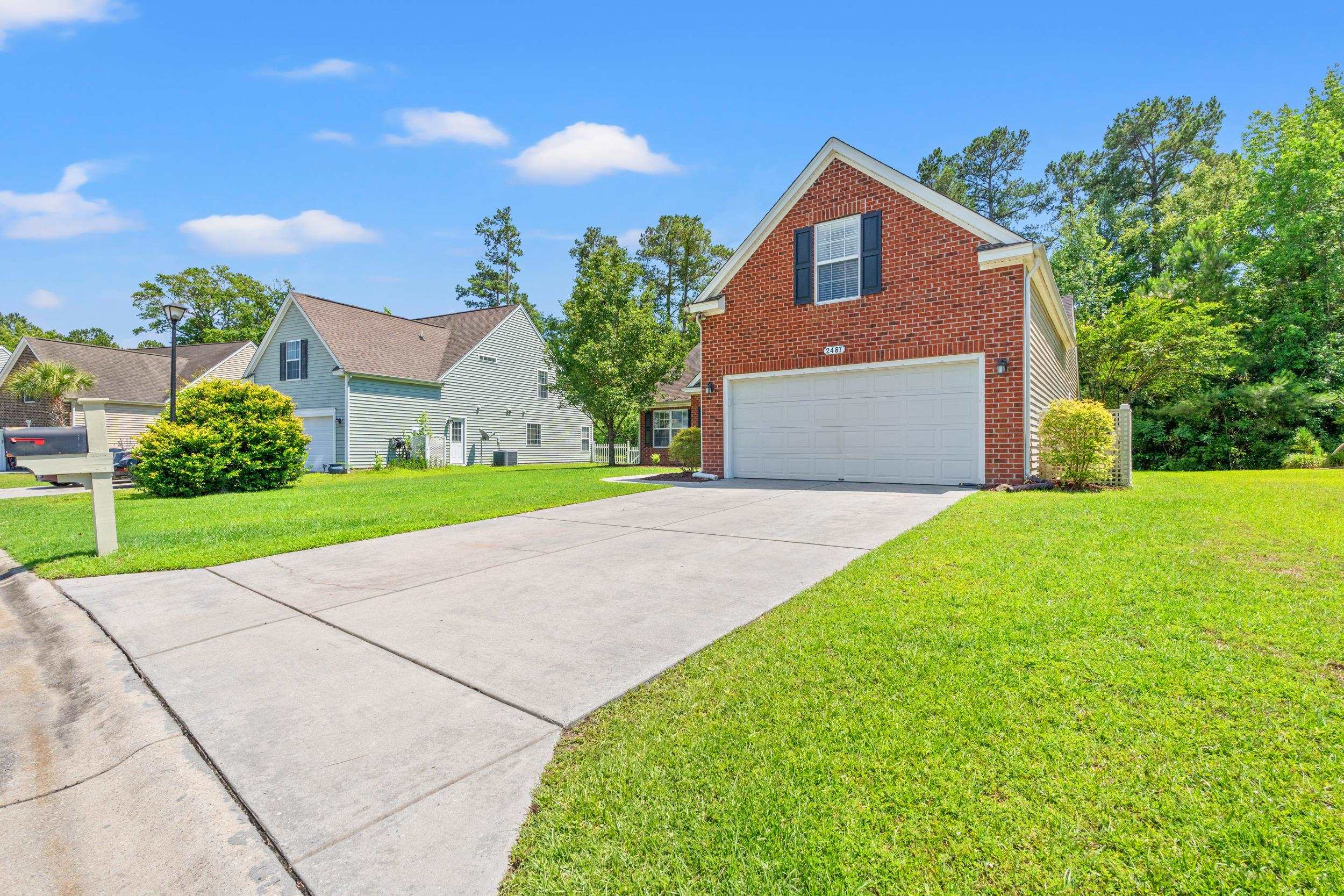 2487 Windmill Way Myrtle Beach, SC 29579 - Photo 4 of 40 View of property exterior featuring brick siding, a lawn, driveway, and an attached garage