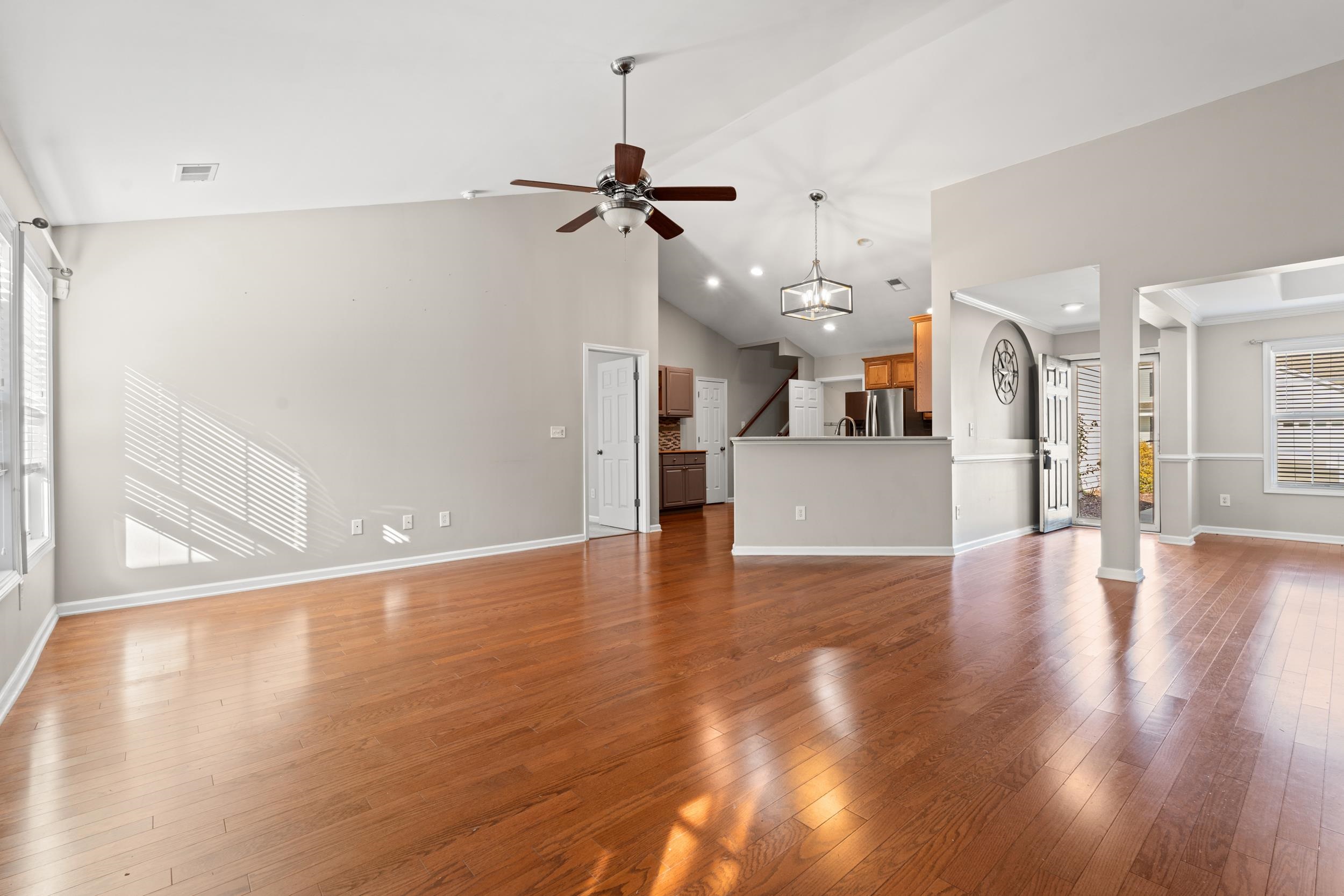 2487 Windmill Way Myrtle Beach, SC 29579 - Photo 10 of 40 Unfurnished living room with light wood-style floors, a ceiling fan, a chandelier, and high vaulted ceiling