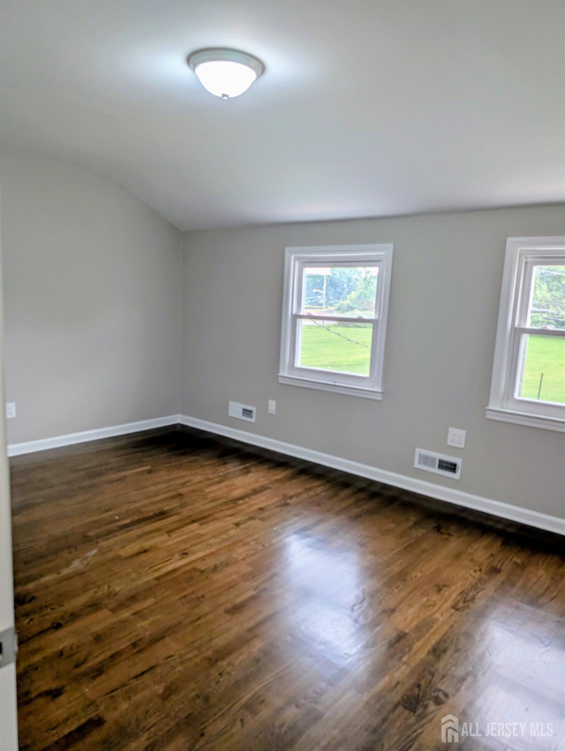 76 Glenville Road, Unit 76 Edison, NJ 08817 - Photo 12 of 13 a view of an empty room with wooden floor and a window