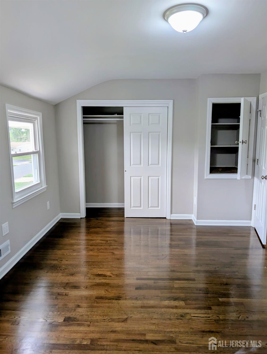 76 Glenville Road, Unit 76 Edison, NJ 08817 - Photo 13 of 13 a view of an empty room with window and wooden floor