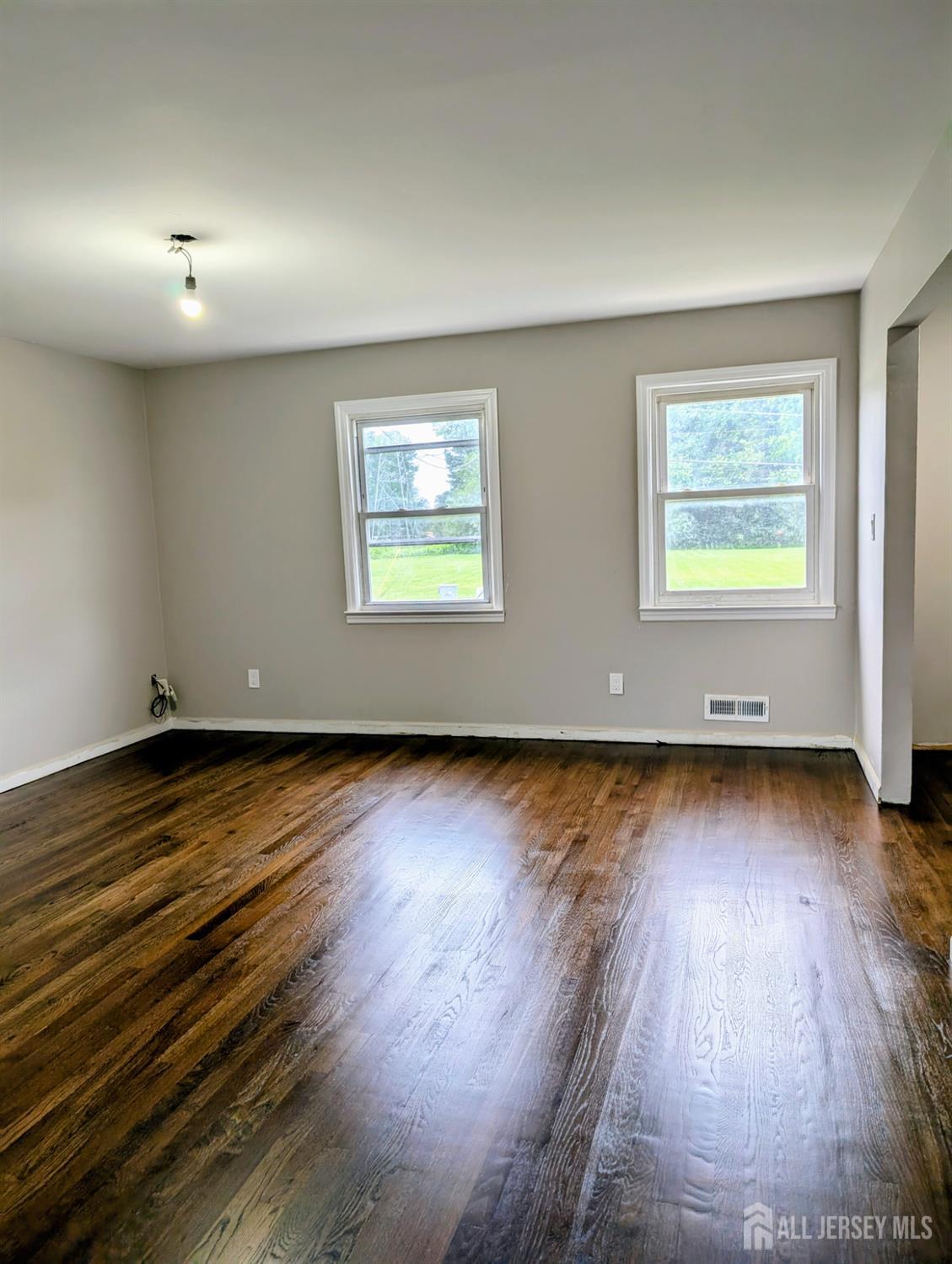 76 Glenville Road, Unit 76 Edison, NJ 08817 - Photo 2 of 13 a view of an empty room with wooden floor and a window