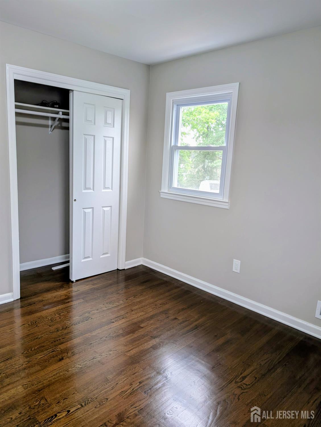 76 Glenville Road, Unit 76 Edison, NJ 08817 - Photo 9 of 13 a view of an empty room with wooden floor and a window