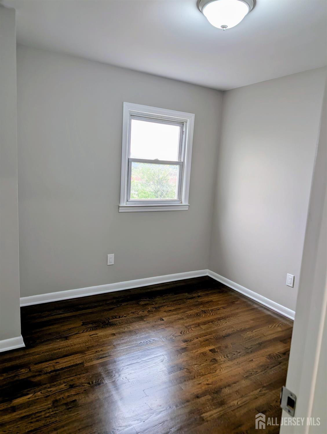 76 Glenville Road, Unit 76 Edison, NJ 08817 - Photo 10 of 13 a view of an empty room with wooden floor and a window