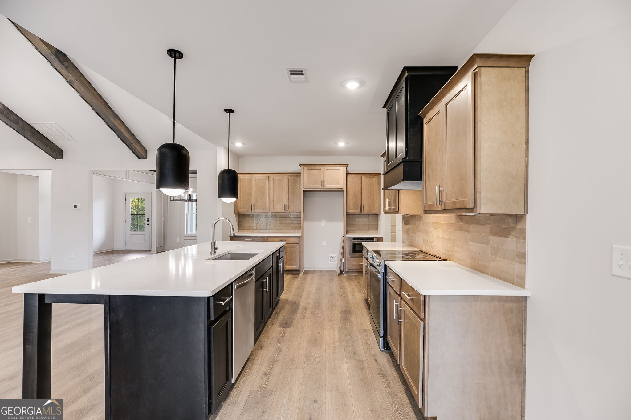 3262 Veal Road Roopville, GA 30170 - Photo 16 of 46 a large kitchen with kitchen island a sink stove and wooden floor