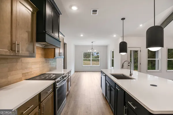 a kitchen with stainless steel appliances kitchen island a large island in the center and wooden floor